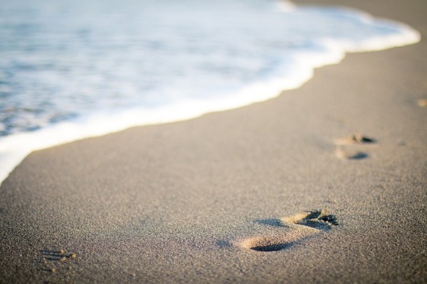 des traces de pas sur une plage avec la mer