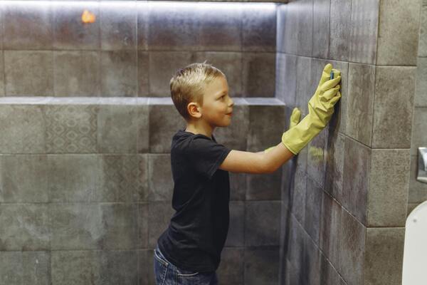 un petit garçon en train de lessiver un mur