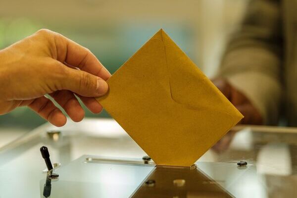 un bulletin de vote prêt à être mis dans une urne un jour d'élection